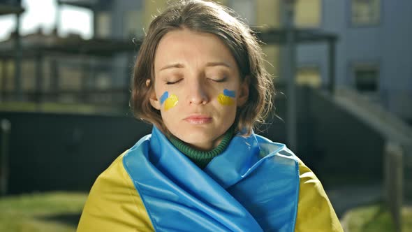 Portrait of a Woman with a Ukrainian Flag on His Shoulders