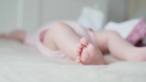 Baby Lying on Bed, Curling Toes while Moving Feet, Selective Focus