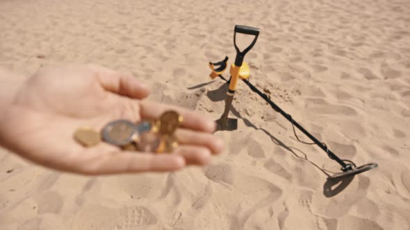 Close Up, Hands with the Coins. Person Searching Sandy Beach with Metal Detector.