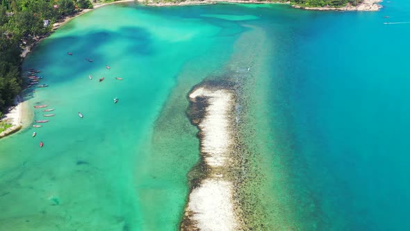 small sandbank in the turquoise waters of the Thailand coast. Lush jungle, sand beach and peaceful s