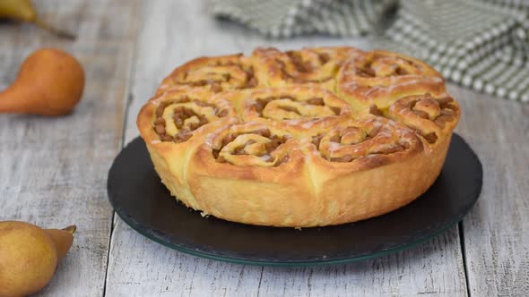 Sweet yeast buns with pear filling on rotating table. Autumn baking