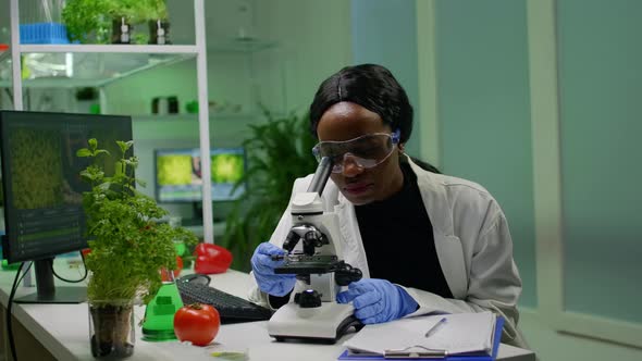 Biologist Researcher Scientist Looking at Leaf Sample Under Medical Microscope