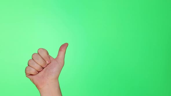 Thumb, well, good sign. Closeup of male hand isolated on green screen background