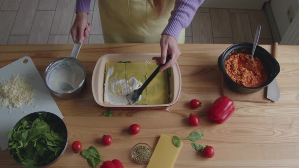 Woman Is Putting Sauce On Lasagna Noodles