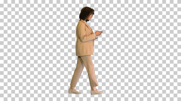 Young African American lady walking and texting, Alpha Channel