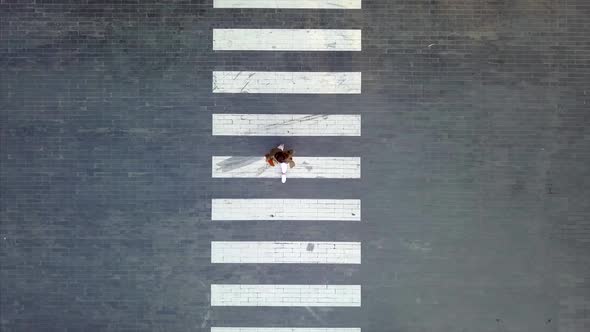 A Woman Crossing On Crosswalk During Evening Day Aerial Shot