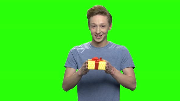 Portrait of Caucasian Teenage Boy Giving Yellow Gift Box for Holiday