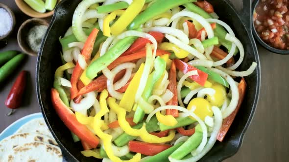 Time-lapse. Step by step. Frying fresh vegetables in large cast iron pan for steak fajitas.