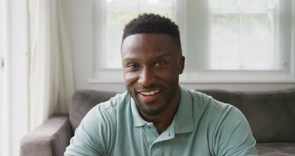 Portrait of happy african american man wearing shirt in living room