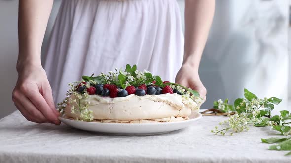 woman hands decorate a meringue cake on the table