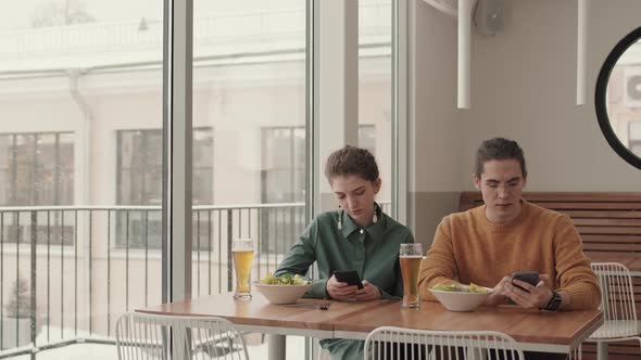 People Using Phones in Cafe