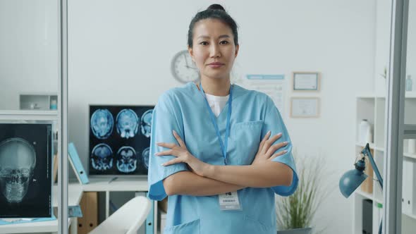 Slow Motion Portrait of Confident Asian Lady Nurse Wearing Scrubs Standing in Clinic