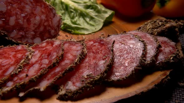 Close-up Panorama of Delicious Dry Sausage in Herbs Taken From a Wooden Board