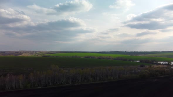 Epic fly above green and cultivated spring fields