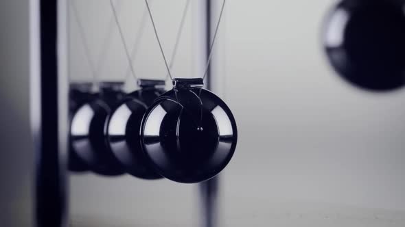 The balls of a Newtons Cradle colliding in slow motion