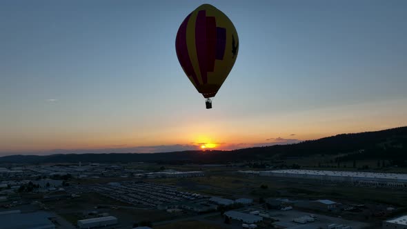 Medium shot of a hot air balloon high in the sky at sunset.