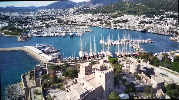 Amazing panoramic view from drone of full of yachts Bodrum harbour and ancient Kalesi castle.