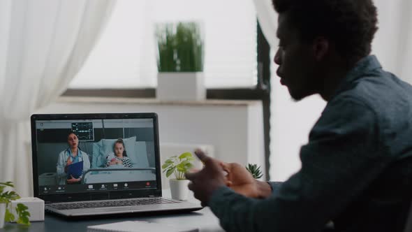 Worried African American Dad for Her Little Girl in Hospital Ward Talking on Video Conference Call