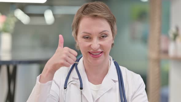 Positive Middle Aged Female Doctor Showing Thumbs Up Sign 