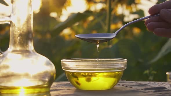 Sunflower Oil Flows From Tablespoon Into Glass Bowl. Production Organic Sunflower Oil, Bottle Of Oil