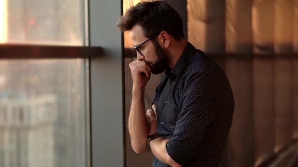 Tired Businessman Looking Out Window. Creative Man Standing Near Windows In Office.