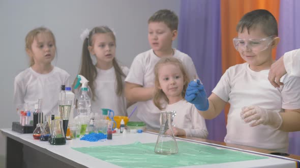 Chemical Experiments for Children. A Woman Adds Ingredients To a Flask for Chemical Experiments. A