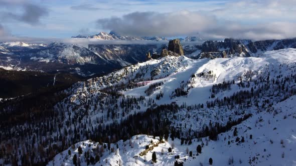 Aerial view of the snowy landscapes of the Italian Dolomites on a partly cloudy day
