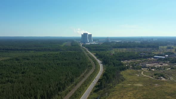 Smoking Cooling Towers at Nuclear Power Plant in Forest with Road. Aerial View