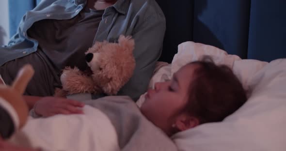 Black Mom Reading Book to Kid at Night