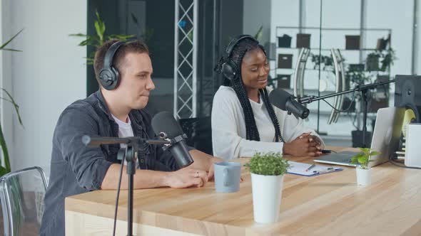 Confident African American Woman With White Man Hosting a Podcast