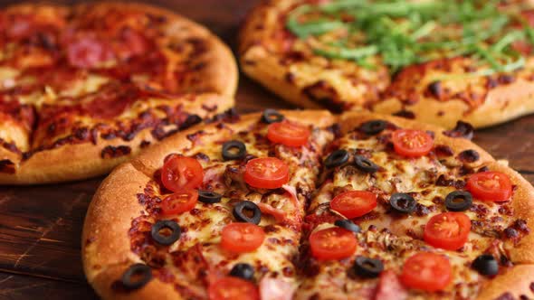 Various Kinds of Pizzas Placed on Wooden Table