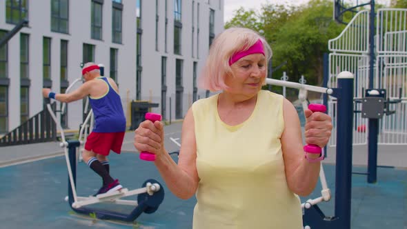 Senior Woman Grandmother Doing Active Training Weightlifting Exercising with Dumbbell on Playground