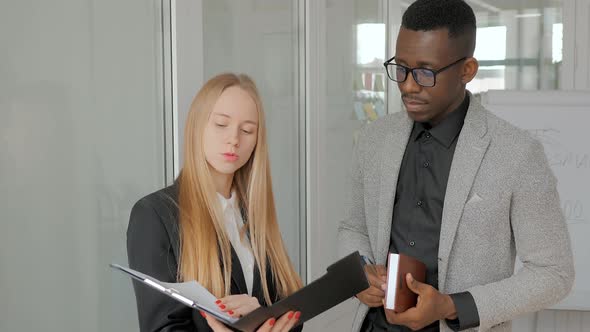 Business Team African American Man and Blonde Woman Discuss Financial Plan Analytics Report Sales of