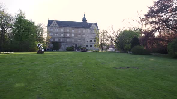 fast travel to Wolfsburg castle façade with people relaxing on bridge in front