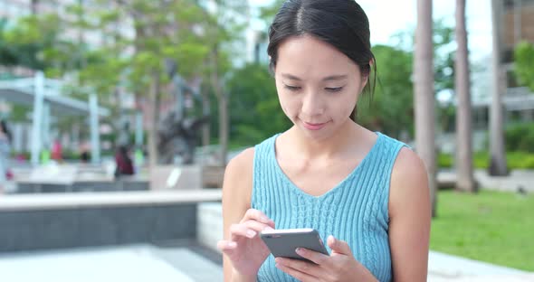 Woman Use of Mobile Phone and Sitting at Outdoor 