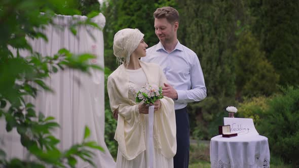 Live Camera Zoom in to Happy Smiling Loving Interracial Couple Standing at Wedding Altar Hugging