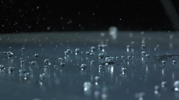 Slow motion of water droplets moving across a metal surface. alt