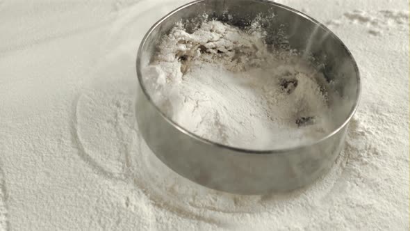 Super Slow Motion on the Table with Flour Falling Sieve