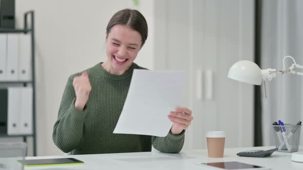 Young Woman with Documents Celebrating Success