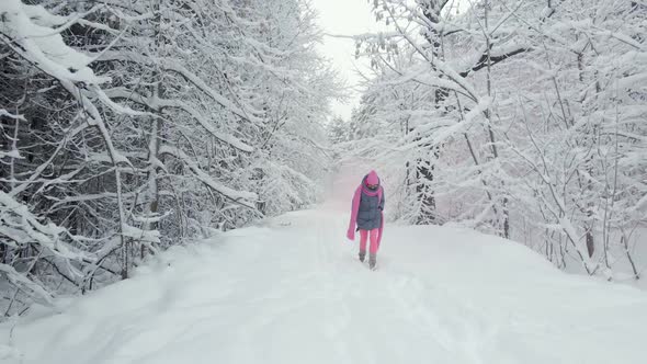 Traveler Woman in Pink Clothes a Scarf and a Hat and Sunglasses is Walking