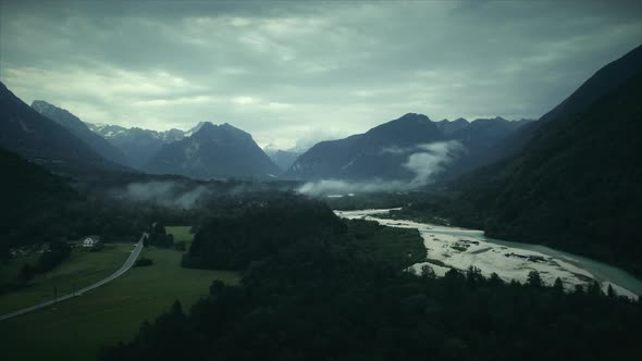 Aerial view of Soca river and car road surrounded by nature in Slovenia.