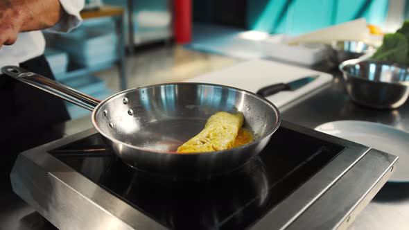 Professional restaurant kitchen, close-up: the process of cooking an omelette in a frying pan