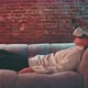 Young woman laying on couch wearing vr goggles - VideoHive Item for Sale