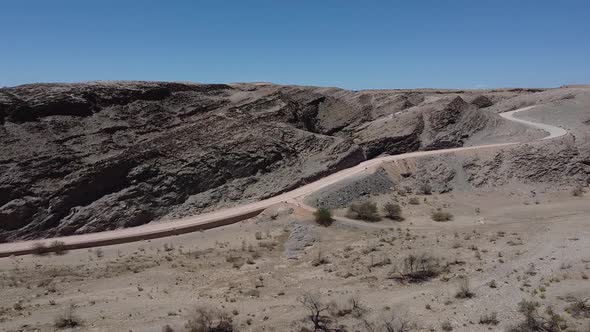 Drone view on a beautiful dusty mountain road in desert region of Namibia