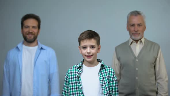 Young Boy Looking at Camera, Middle-Aged and Senior Men on Background, Support