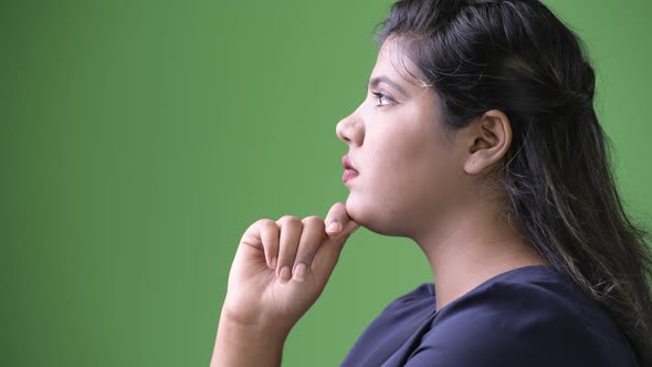 Young Overweight Beautiful Indian Businesswoman Against Green Background