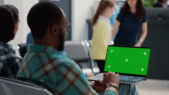 African American Man Using Laptop with Greenscreen on Display