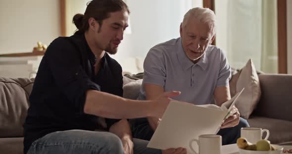 Father and Son Examining Photos Together