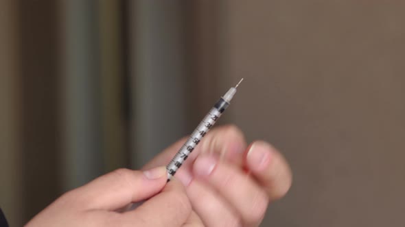 Girl's Hands with an Insulin Syringe Closeup