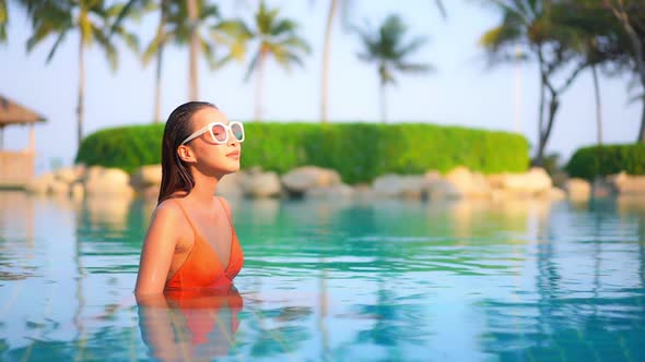 Young asian woman enjoy around outdoor swimming pool for leisure